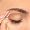 Close up image of a woman's eye and eyebrow showing her plucking her brows