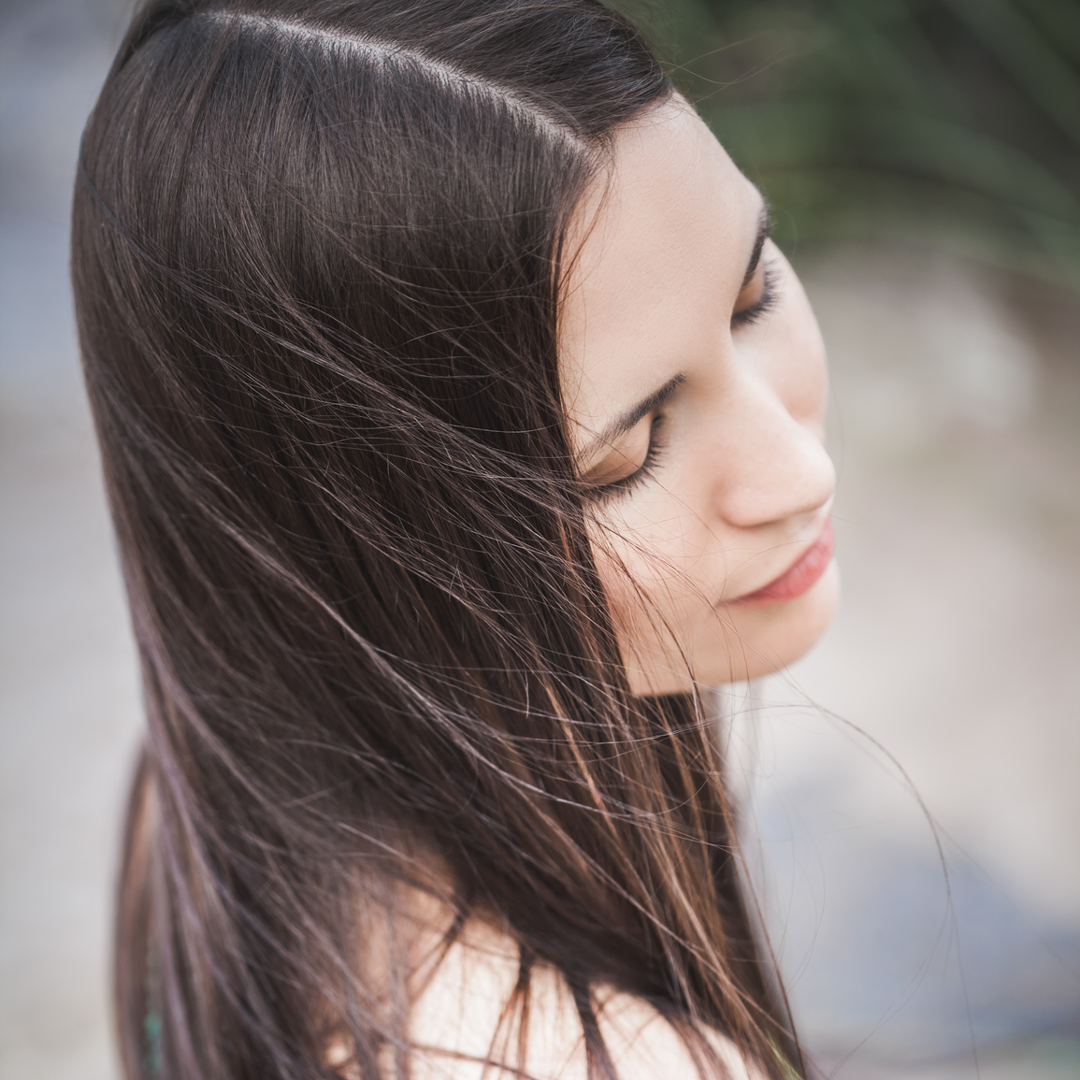 Image of woman with her head tilted slightly down showing off her hair