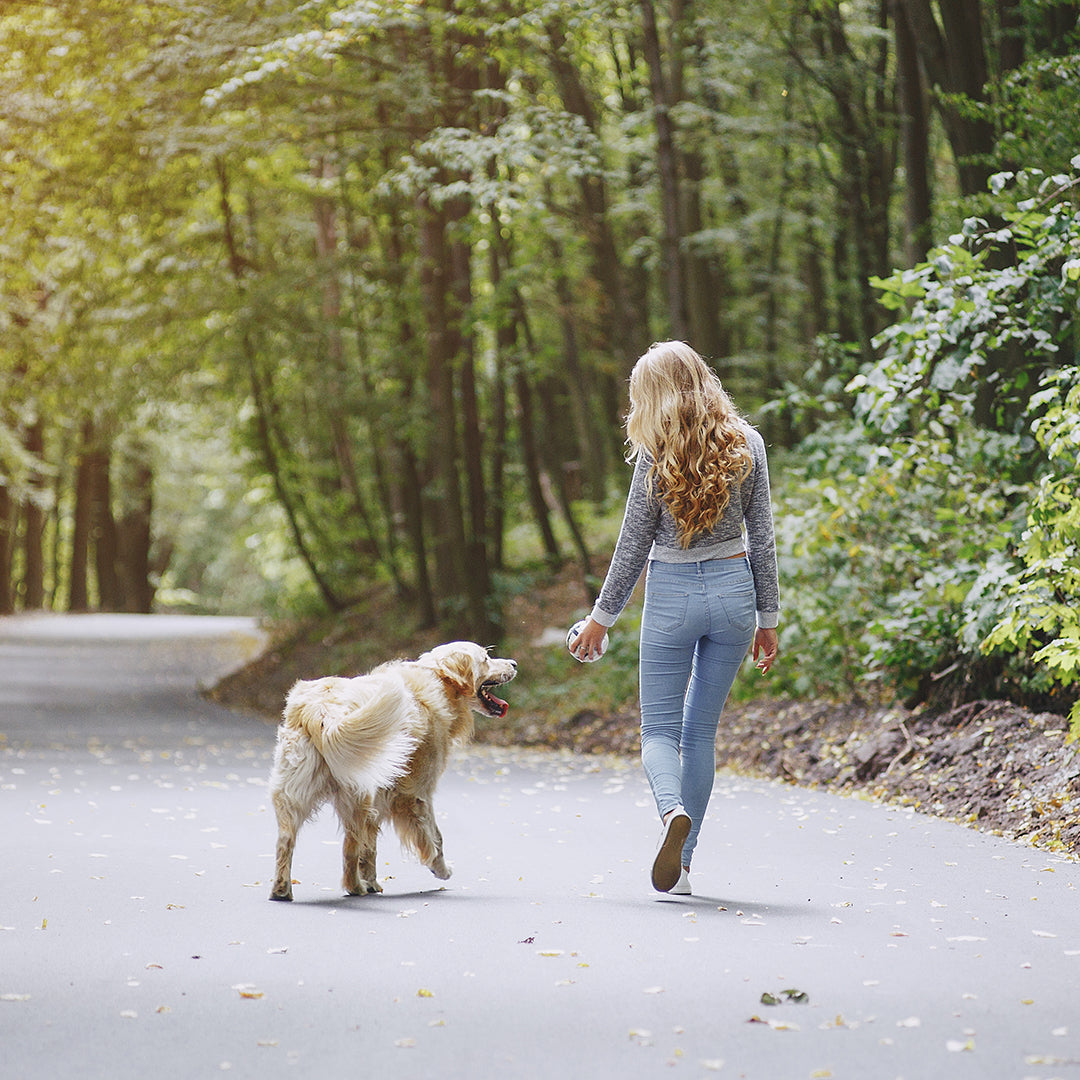 image of woman walking with dog outside