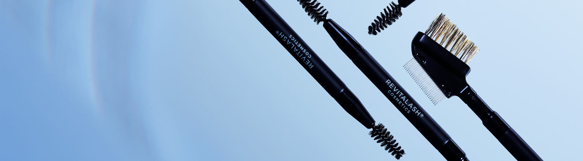 Eyebrow grooming tools including a pencil, brush, and comb on a light blue background.