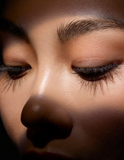 Close-up of a person's face with a focus on the nose and eyes. 25% off sitewide $100 purchase.