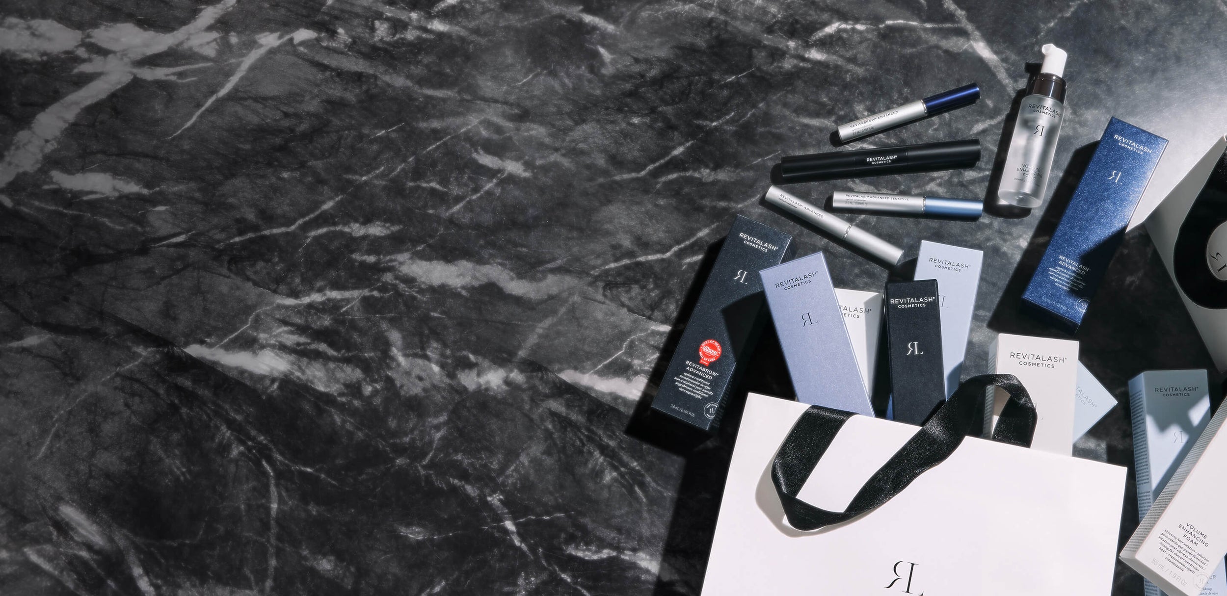 Cosmetic products and packaging on a dark marble surface. 25% off sitewide $100 purchase.