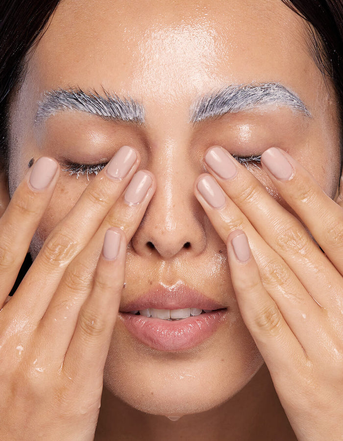 model  cleansing post Lash and Brow Masque application to eyebrows and eyelashes