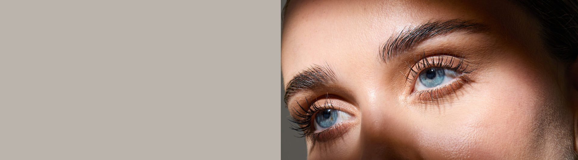 Close-up of a person's eyes with a neutral background. Model is actual RevitaLash® Cosmetics user. 25% off sitewide $100 purchase.