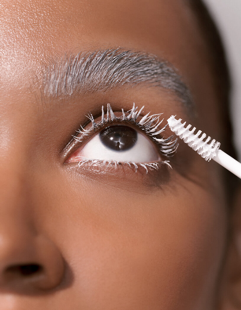 Close-up of a person applying lash & brow masque with a brush