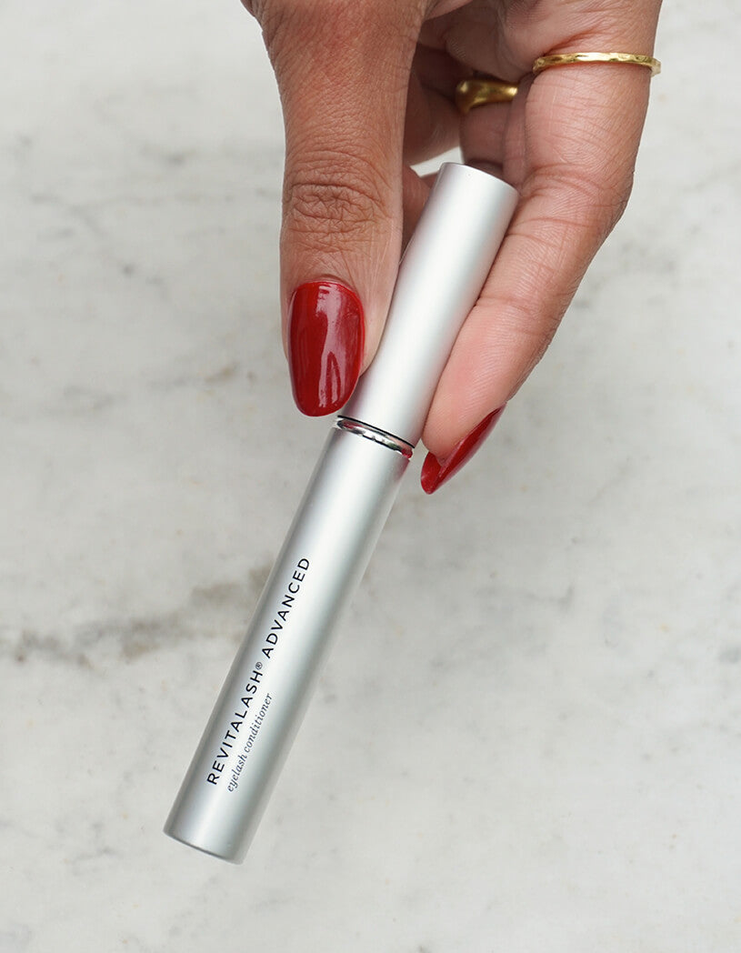 RLA held by a hand with red nail polish on a light gray background