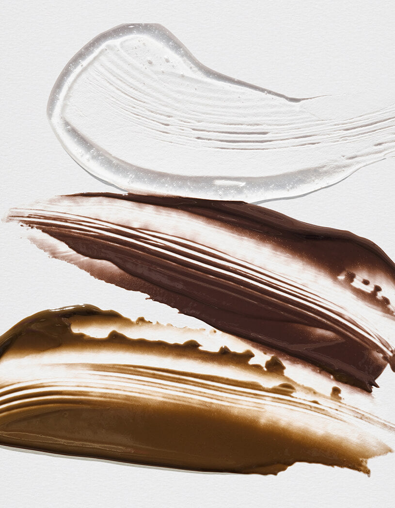 Close-up of brown and clear cosmetic products on a light gray background